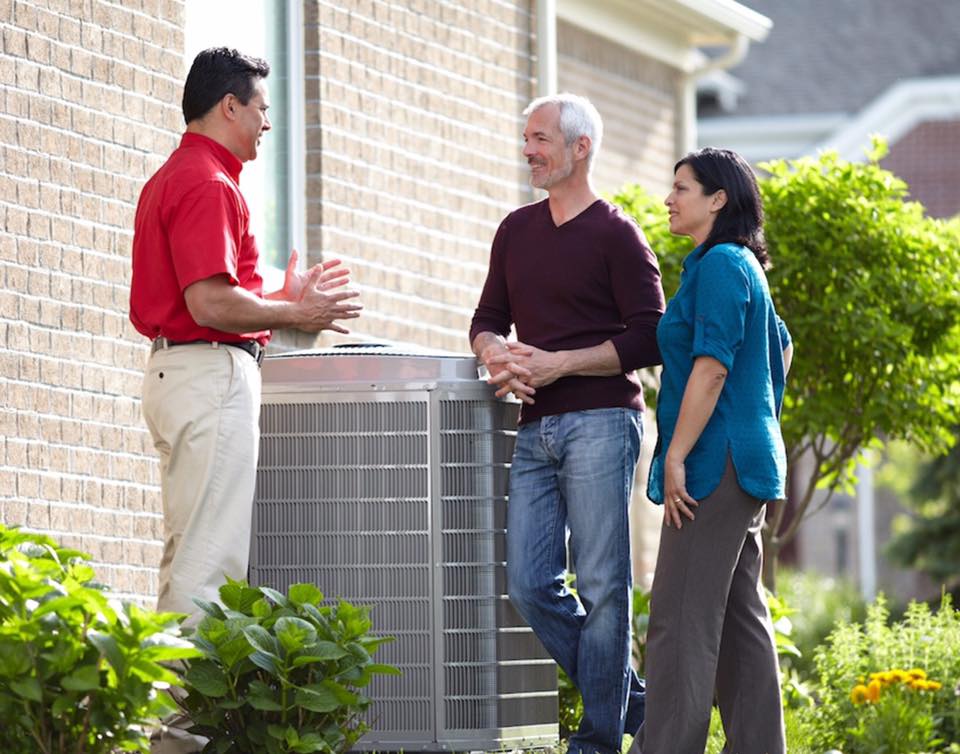Professional HVAC technician installing air conditioning unit in a San Diego home.