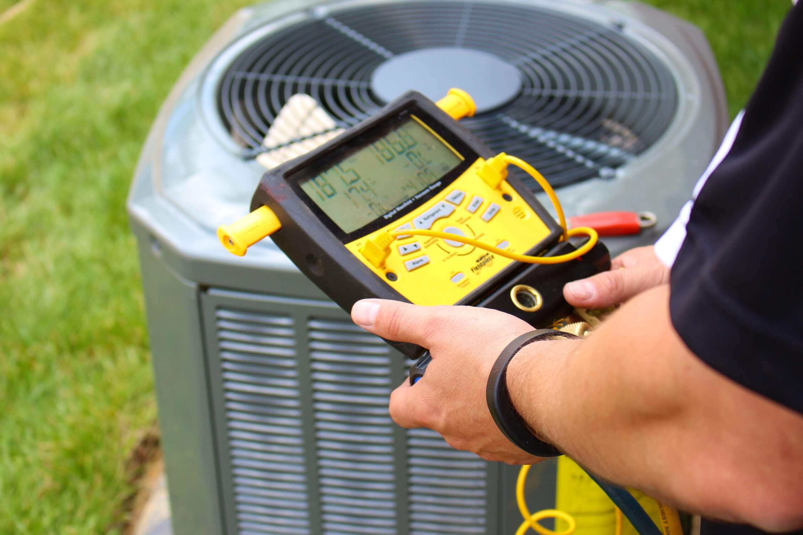Technician repairing a central air conditioning unit in a residential home in Coronado, CA.